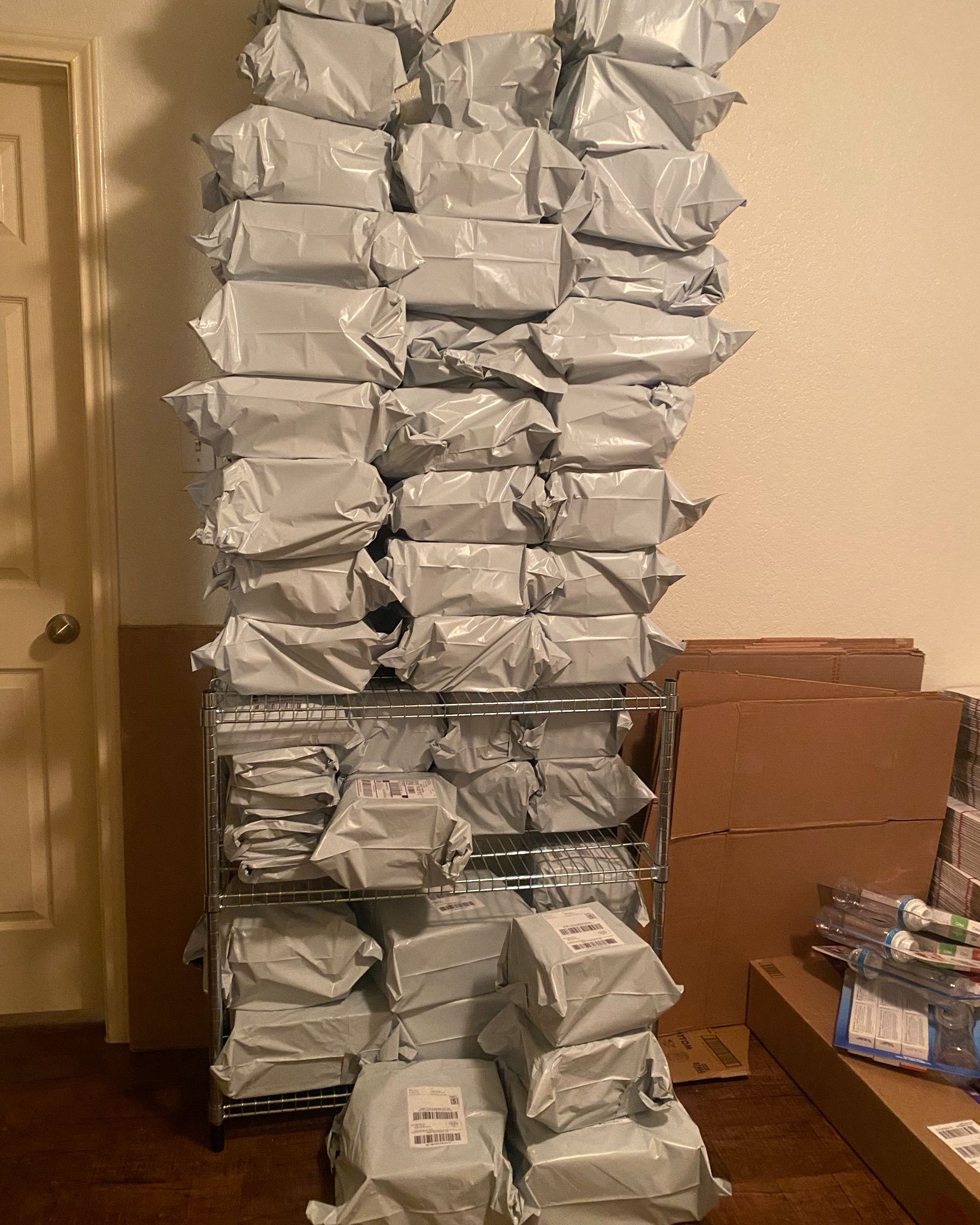 High stacks of wrapped packages in warehouse storage with organized wire shelving system