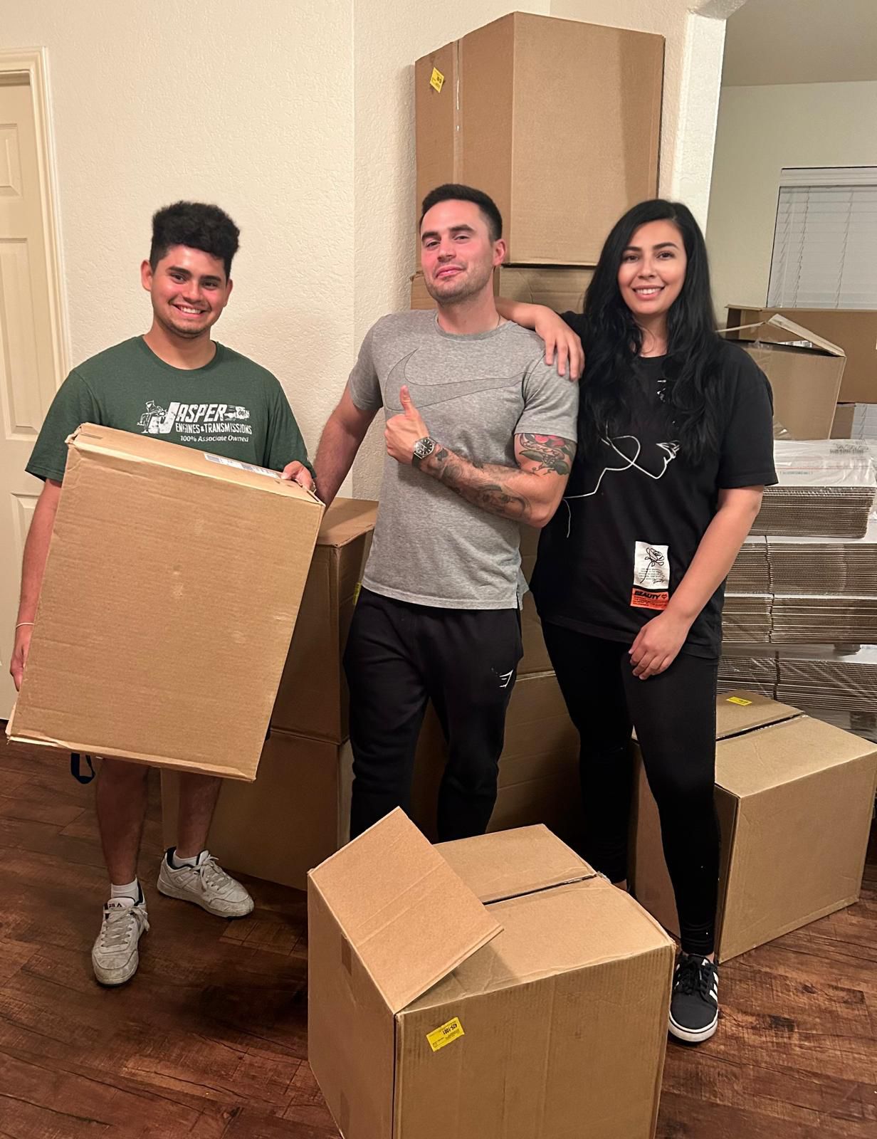 Guillermo, Victoria, and Michael - the founding team of Supplies by CNC LLC working together in their warehouse surrounded by shipping boxes